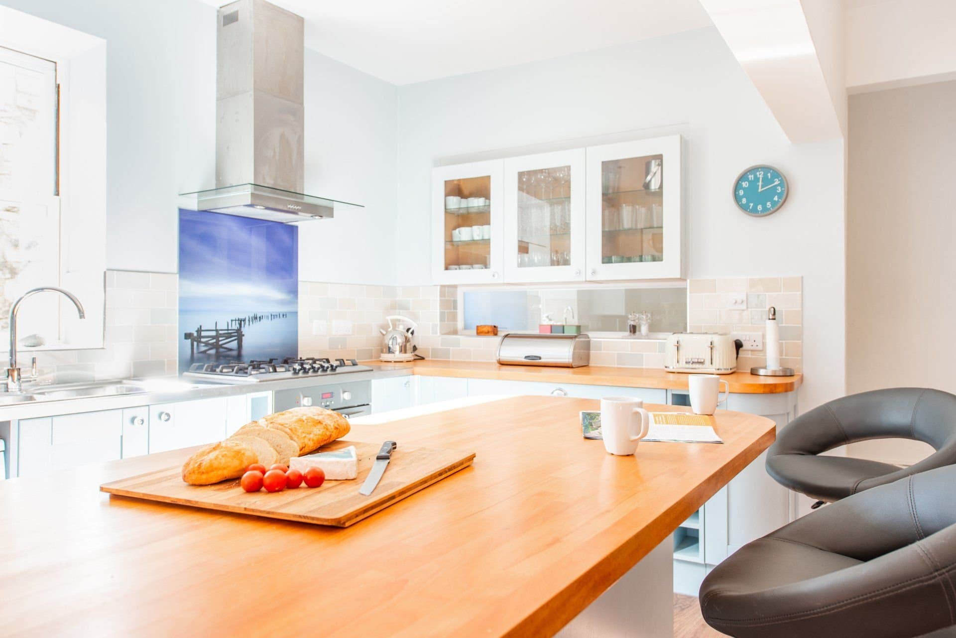 Breakfast bar with bread and tomatoes, looking along the kitchen