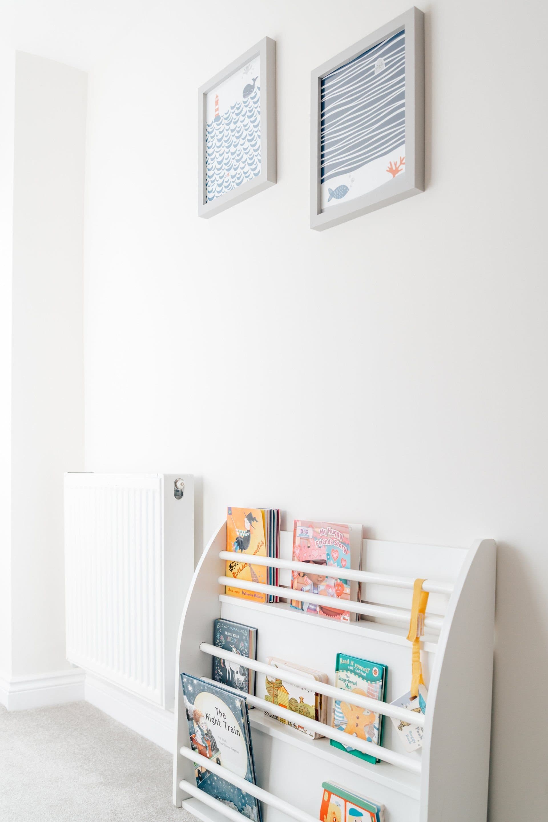 Children's books on a low shelf in a bedroom