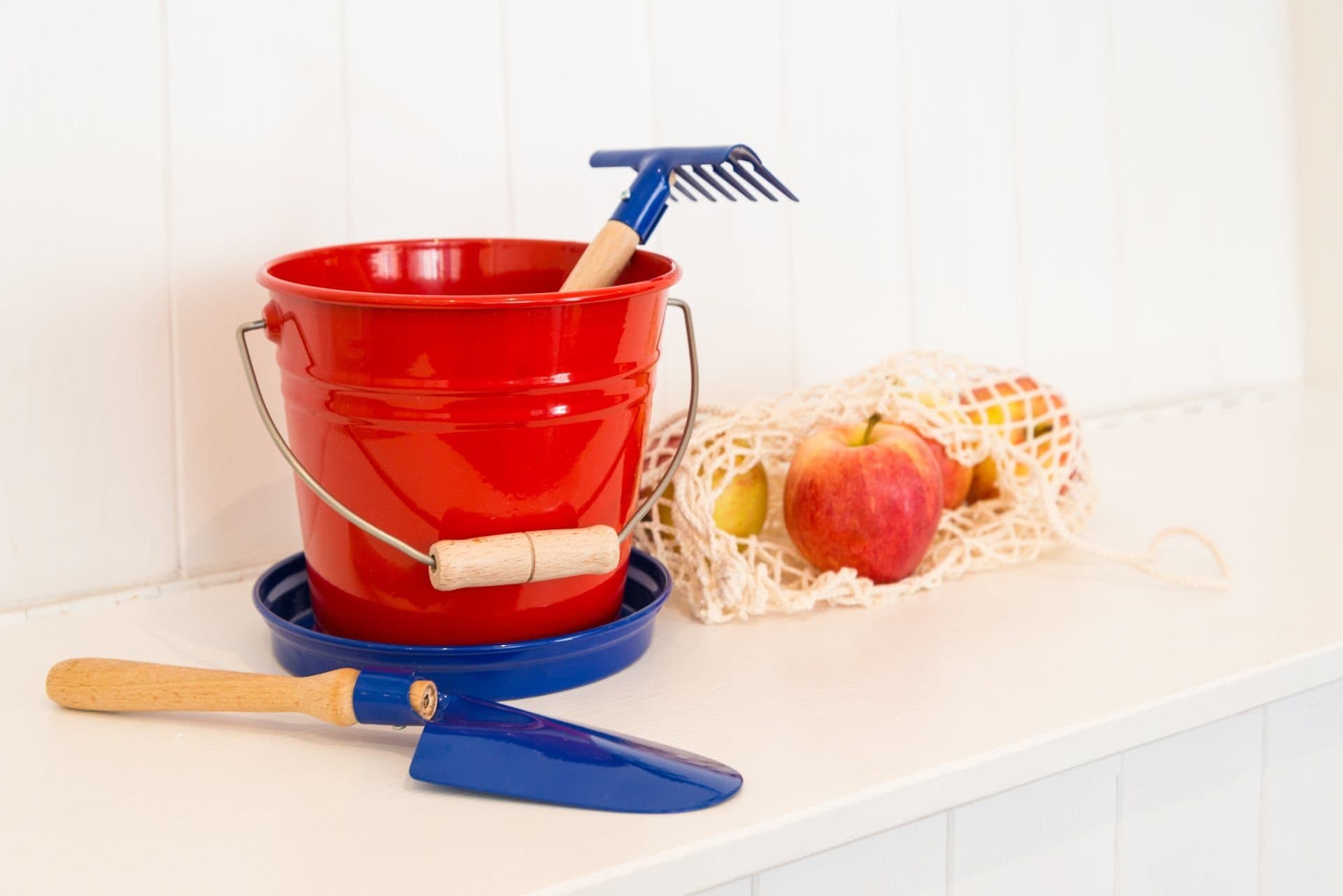 Beach bucket, spade and a bag of apples on the entrance bench